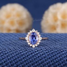 a tan and white diamond ring with an oval blue sapphire