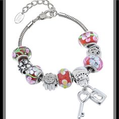 Beautiful Charm Bracelet Features Red And Pink Murano Glass Beads, Rhodium Plated Stainless Steel Carved Charm Beads, And The Beautiful Lock And Key Charm. The Bracelet Is A Sleek Snake Stain Which Is Also Made Of Rhodium Plated Stainless Steel. It Is Approximately 7 Inches Long With A 1.5 Inch Extender. There Is A Lobster Claw Clasp. Red Beaded Bracelets With Charms, Adjustable Silver Charm Bracelet With Colorful Beads, Silver Beaded Bracelets With Colorful Beads, Adjustable Silver Beads, Red Metal Crystal Bracelet Gift, Silver Adjustable Beads With Lobster Clasp, Silver Beaded Charm Bracelet For Party, Metal Silver Beads For Gifts, Adjustable Silver Beads With Lobster Clasp