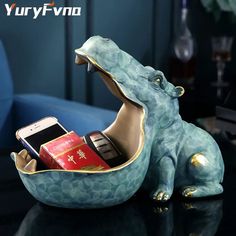 an elephant shaped cell phone holder on top of a table with other items in it