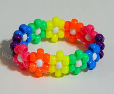 a rainbow colored bracelet with lots of beads on it's end and one bead in the middle