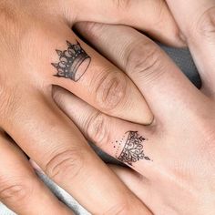 two people with matching rings on their fingers and one has a crown tattoo on it