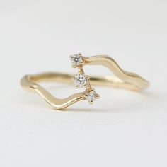 a gold ring with three diamonds on it