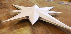 an origami star on a table with the words apply adhesive to both tabs