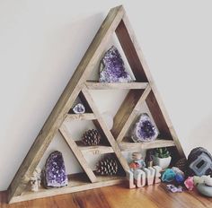 a wooden shelf with various items on top of it, including rocks and stones in the shape of a triangle