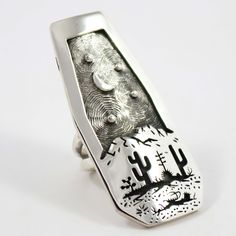 Sterling Silver Ring with an Intricate Overlaid Desert Scene Design including a Crescent Moon in the Sky by Tohono O’Odham and Akmel O’Odham Silversmith, Rick Manuel. Ring Size: 7.5 1” Setting Width, 2.25” Setting Height .25” Band Width Moon In The Sky, Silver Smithing, Desert Scene, Zuni Jewelry, Concho Belt, Navajo Jewelry, Scene Design, Native Jewelry, Pendant Rings