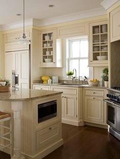 a large kitchen with an island in the middle and lots of cabinets on both sides