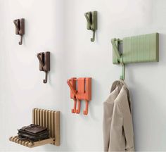 a coat rack with two coats hanging on it and some hooks attached to the wall