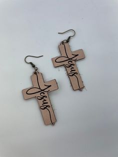 "Each tan-colored leather cross earring bears the graceful script of \"Jesus\" in cursive, adding a personal and intimate touch to your expression of faith. These handmade leather cross earrings make for a perfect present for those who appreciate the harmony of faith and style. Share the beauty of devotion with these elegant earrings that carry a heartfelt message." Cross Earring, In Cursive, Neutral Minimalist, Cross Earrings, Leather Cross, Colored Leather, Elegant Earrings, Tan Color, Handmade Leather