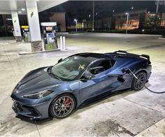 a blue sports car parked at a gas station