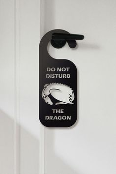 a door hanger that says do not disturb the dragon with sunglasses hanging on it