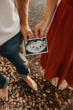 a man and woman standing next to each other holding an image in front of them