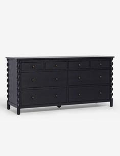 a black dresser with gold knobs on the top and bottom, against a white background