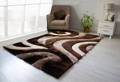 a living room with a chair and rug in the middle on the floor next to a window