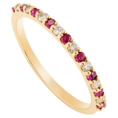 a yellow gold ring with red and white stones