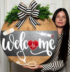 a woman holding up a sign that says welcome to the doctor and stethoscope on it