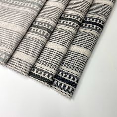 four black and white striped rugs sitting on top of a table next to each other