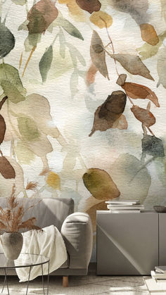 a living room with a couch, chair and wallpaper that has watercolor leaves on it