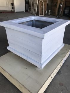 a large white planter sitting on top of a box