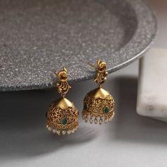 These antique earrings feature a simple jhumki design. Antique gold-tone plated earrings, crafted with peacock motif stud, are attached to the jhumki-shaped filigree design . Ideal for simple occasions and for young girls. Details & Specifications: Materials used: Brass Alloy with Antique Plating Weight - Earrings 16 gm Length - Earrings 4 cm Make it custom Want to make it a custom earring? Sure! Reach out to us at support@tarinika.com and we’ll be happy to make possible modifications at no extr Temple Jewelry Brass Jhumkas As Gift, Brass Chandbalis With Intricate Design For Gift, Elegant Brass Jhumkas For Diwali, Gift Brass Jhumkas With Latkans, Festive Brass Jhumkas With Intricate Design, Festival Brass Drop Jhumkas, Brass Temple Jewelry Jhumkas, Elegant Festive Jhumkas With Peacock Design, Festive Jhumkas With Peacock Design