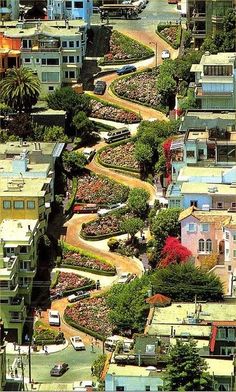 an aerial view of a city with lots of buildings and trees in the foreground