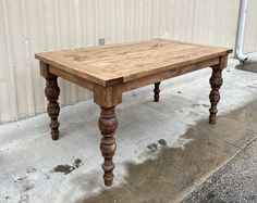 a wooden table sitting on top of a sidewalk