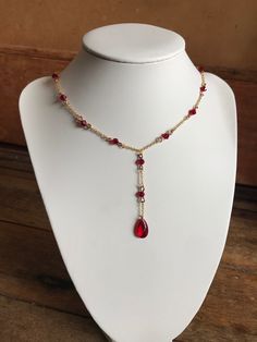 this necklace features a deep, blood-red gemstone, adorned with glass red beads and tarnish resistant chains for those who embrace the darkness with elegance. Red Beaded Ruby Necklace, Elegant Red Beaded Chain Necklace, Red Adjustable Chain Necklace For Party, Red Beaded Chain Necklace Gift, Gift Red Beaded Chain Necklace, Red Beaded Chain Necklace For Gift, Elegant Red Wire Wrapped Necklace, Blood Necklace, Vampire Style