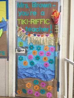 a door decorated with paper flowers and writing on the front, says mrs brown you're a tiki - riffic teacher