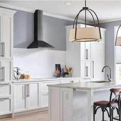 a kitchen with white cabinets and an island