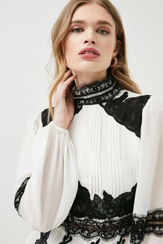 Bringing A Sense Of Opulent Gothic Glamour To High Summer, This Gauzy Woven Blouse Blends Delicate Lace Panels With Crisp Front Presses And Romantic Puff Sleeves. Spin Around To Showcase The Unexpected Back Cut-Out - A Modern Detail That Instantly Revives The Polished, High-Necked Silhouette. Elegant Fall Blouse With Lace Patchwork, Elegant Lace Patchwork Blouse For Fall, Elegant Lace Patchwork Top For Fall, Elegant Fall Lace Patchwork Top, Chic Formal Blouse With Lace Patchwork, Gothic Lace Tops For Fall, Gothic Long Sleeve Blouse For Evening, Gothic Lace Top For Fall, Spring Season Gothic Formal Tops