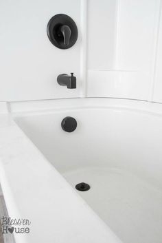 a white bath tub sitting under a faucet