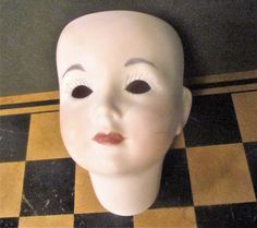 a white mannequin's head on a black and yellow checkered floor