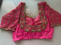 Pink Pattu silk Maggam blouse with bell motifs and kundan work on neckline and sleeves. Note - Doris and Latkans provided are complementary so please do not complain about them. We do our best to put best latkans for you. Disclaimer - Actual colors may vary slightly due to computer monitors displaying settings. We try hard to match exact color. For sizes 42+ we charge extra $20 for fabric and workmanship. Please contact us before placing order, we will send you link to pay extra $20. Designer Festive Blouse Piece For Diwali, Designer Festive Blouse For Diwali, Pink Silk Choli With Motifs, Designer Festive Choli With Pallu, Traditional Drape Kundan Blouse, Designer Choli With Pallu For Festive Occasions, Traditional Multicolor Dola Silk Blouse, Zari Work Kundan Blouse, Designer Kundan Blouse With Traditional Drape