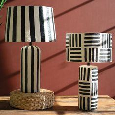 three black and white lamps sitting on top of a wooden table