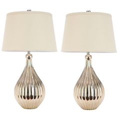 two silver lamps with white shades on them