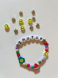 a bracelet with smiley faces, stars and other charms on it that says shut up