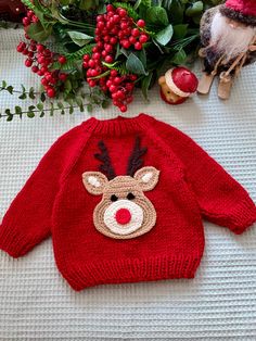 a knitted reindeer sweater sitting on top of a table