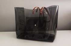 Standard Shipping = Express Shipping by Fedex Oversize vinyl bag, huge bag, transparent bag, black and clear handbag, city style bag, security bag, everyday handbag, unique big bag Dimensions: 42 x 36 x 20 cm// 16,5 x 14,17 x 8 iches Made of thick, crystalline, flexible PVC. One side black and ane transparent clear. Leather straps colour to choose ( in the picture caramel) A large handbag city, type of shopper . The modern concept of boho style , oversize . Large transparent BAG with large , sol Security Bag, Clear Handbags, Handbags Collection, Collection Ideas, Bag Transparent, Vinyl Bag, Everyday Handbag, Transparent Bag, Luxury Packaging