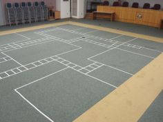 an empty basketball court with chairs in the background