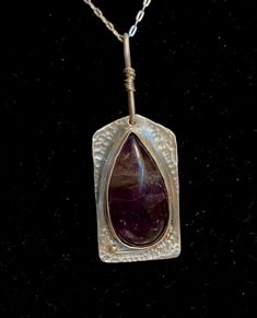 "Handmade sterling and deep purple amethyst necklace with a teardrop stone and shaped silver backplate.  Amethyst is a February birthstone, but this is fashionable all year round.  Pendant measures 1 3/8\" long and has a 3/4\" peanut shaped bail that is wrapped in fine silver wire.  Beautifully hand textured for extra shine and sparkle.   Comes with a 18\" sterling silver chain. Thank you for visiting Studio729!  I welcome your questions and business.  To see more of my handmade jewelry, just cl Spiritual Sterling Silver Teardrop Necklace, Amulet Style Teardrop Gemstone Jewelry, Amulet Style Jewelry With Teardrop Gemstone, Hand Forged Teardrop Pendant Necklace, Spiritual Nickel-free Teardrop Necklace, Sterling Silver Gemstone Long Drop Necklace, Hand Forged Purple Pendant Necklace, Hand-forged Purple Pendant Necklace, Teardrop Gemstone Necklaces For Healing