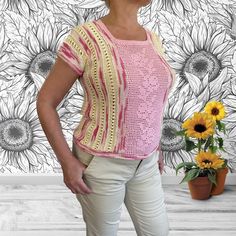 a woman standing in front of a wall with sunflowers