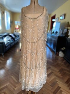 "A truly spectacular 1920s flapper gown.  The under layer is made of blush pink silk with gold bullion lace trim shaped in a scallop design.  The outer layer is fine tulle that has hundreds of tiny flowerettes sewn onto in it overlapping oval pattern.  It appears all these tiny flowers have been hand sewn onto the dress. The hemline is scalloped on outer and under layers and the slip also has another two layers of scalloped tulle at the hemline. Wedding-dress worthy. It's in remarkable condition 1920s Embellished Flapper Dress For Wedding, Flapper Gown, Scallop Design, 1920s Flapper, Gold Bullion, Embroidered Tulle, Tulle Gown, Tiny Flowers, Pink Silk