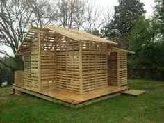 a wooden structure sitting on top of a lush green field