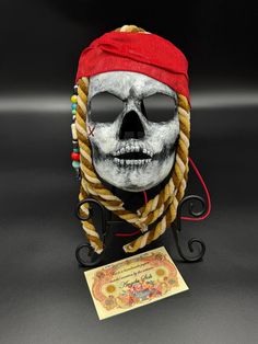 This papier-mâché Pirate skull is truly one-of-a-kind. Made with high-quality materials this mask is perfect as a decoration or can be worn by youth ages 7-12. If solely wanting to display this work of art, it can be tied from behind and hung directly on a wall, or displayed on a stand as shown. This can be used/worn/displayed not just for the Halloween season, but all year round. The face portion measures roughly 8" ~ not including the embellishments. (Hat, hair, etc.) Hat Hair, Costume Masks, Skull Mask, Pirate Skull, Costume Mask, Halloween Season, Costume Accessories, Halloween Shopping, Gift Shop