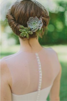 a woman with a flower in her hair is wearing a white dress and pearls necklace