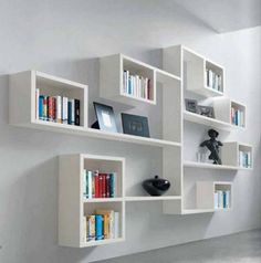 the bookshelves are all white and have many different types of books on them