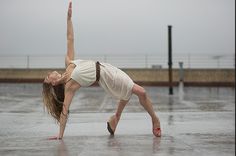 a woman is doing yoga in the rain