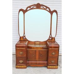 an antique wooden vanity with mirror and drawers