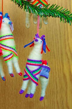 two llama ornaments hanging from a christmas tree