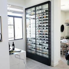 a woman taking a photo of a wine rack