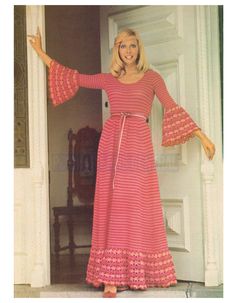 a woman in a red and pink dress is standing by the door with her arms outstretched